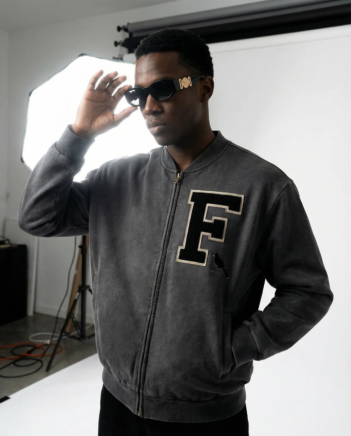 Charcoal gray Vintage Washed Fleece Baseball Jacket with varsity-style 'F' patch, worn by male model under studio lighting.