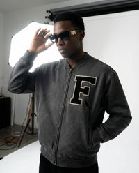 Charcoal gray Vintage Washed Fleece Baseball Jacket with varsity-style 'F' patch, worn by male model under studio lighting.