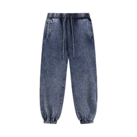 Dark blue unisex sweatpants in snow wash finish with drawstring waist and pockets. Comfortable cotton blend for versatile casual outfits.