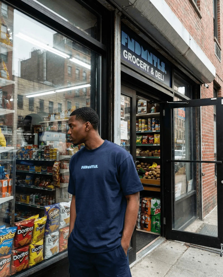Man standing outside a grocery store with open door