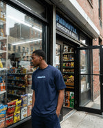 Man standing outside a grocery store with open door