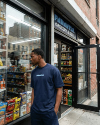Man standing outside a grocery store with open door