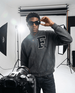 Oversized Vintage Washed Fleece Baseball Jacket featuring bold 'F' patch and bird embroidery, styled with sunglasses in photo shoot.