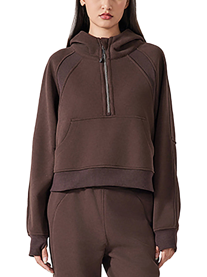 Front view of model in chocolate brown cropped half-zip hoodie for women, highlighting the sporty fit and ribbed hem.