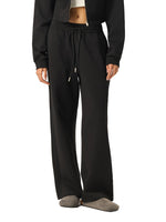 Side view of model in black Essential Drawstring Straight-Leg Sweatpants, showcasing relaxed fit and drawstring waist.