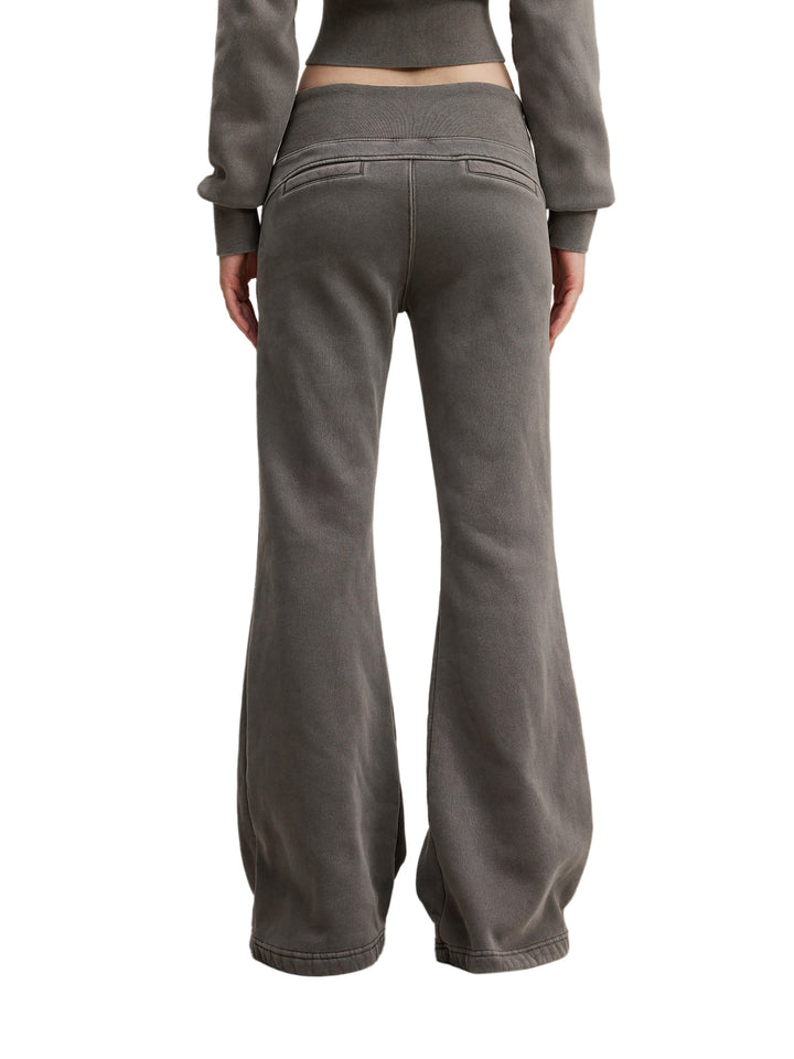 Back view of model wearing charcoal gray Vintage Washed Flared Fleece Pants with faux back pockets and wide-leg cut for a laid-back vibe.