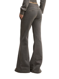 Angled rear view of model in charcoal gray Vintage Washed Flared Fleece Pants highlighting the flared silhouette and pocket details.