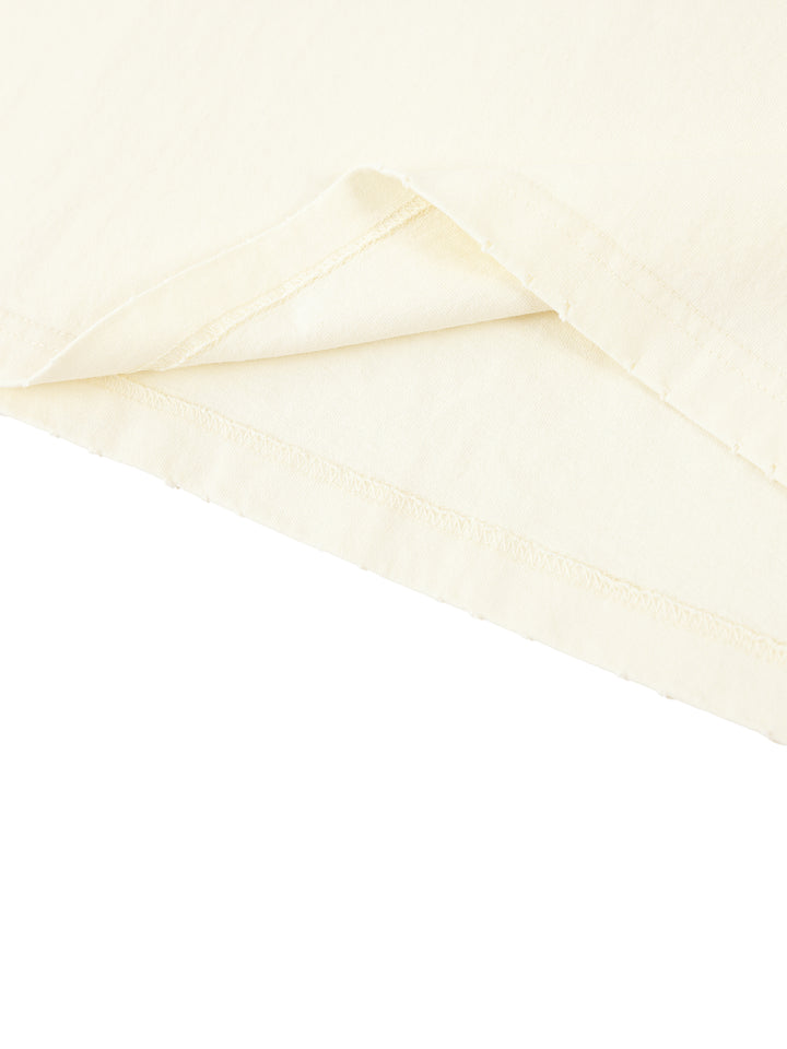 Slightly folded bottom of the light apricot Standard Bearer Vintage Wash T-Shirt to display the quality of the t-shirt