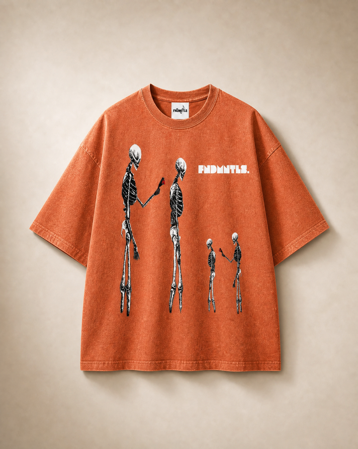 An orange short-sleeve t-shirt with a graphic of three black and white skeletons standing in a row, with the word 'FINDWATLS.' printed in white next to them.